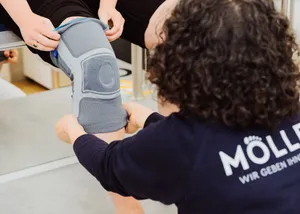 Mitarbeiterin bei der Anpassung einer Kniebandage